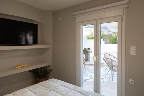 a bedroom with a bed and a sliding glass door at Garden Apartment in Amarynthos I in Amarynthos