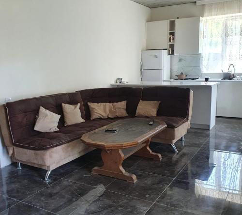 a living room with a brown couch and a table at Racha - ABA in Ambrolauri