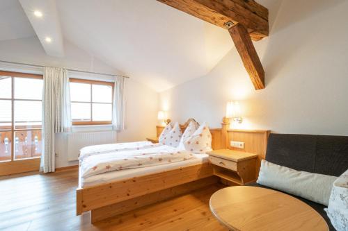 1 dormitorio con cama de madera y sofá en Bio-Bauernhof Nichlgut en Eben im Pongau