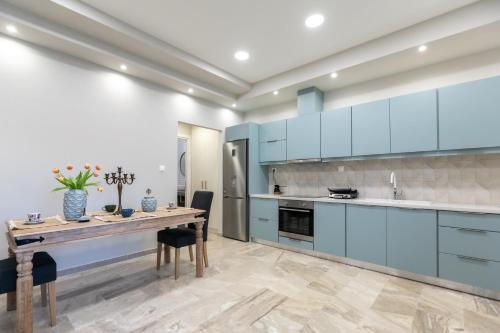 a kitchen with blue cabinets and a wooden table at Garden Apartment in Amarynthos I in Amarynthos