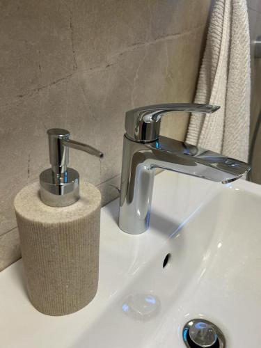 a bathroom sink with a faucet and a paper towel roll at LA Studio in Maribor