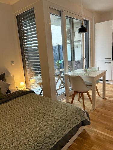 a bedroom with a bed and a table and a dining room at LA Studio in Maribor