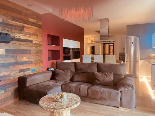 sala de estar con sofá marrón y mesa en Casa Serendipia en La Asomada