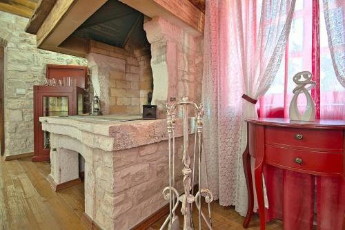 a kitchen with a stone fireplace and a red dresser at San Niccolo in Vilanija