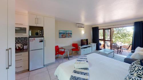 a kitchen and living room with a bed in a room at San Lameer Villa 2514 by Top Destinations Rentals in Southbroom