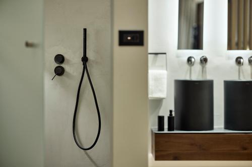 a bathroom with a black shower head on a wall at Icon Suite in Athens