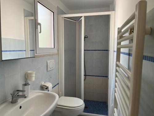 Baño blanco con lavabo y aseo en Appartements dans agréable maison de ville centre historique de Rimini, en Rímini