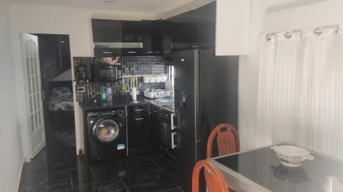 uma cozinha com um frigorífico preto e uma máquina de lavar e secar roupa em Cannes Centre em Cannes