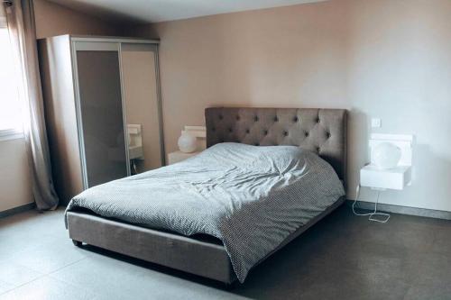 une chambre avec un grand lit avec une tête de lit dans l'établissement Villa sur les hauteurs de Bandol Sanary-sur-mer, à Sanary-sur-Mer