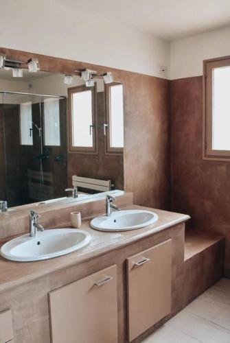 une salle de bain avec deux lavabos et un grand miroir dans l'établissement Villa sur les hauteurs de Bandol Sanary-sur-mer, à Sanary-sur-Mer