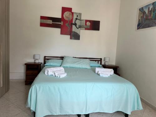 Un dormitorio con una cama azul con toallas. en Calamaterdomini a 2 passi dal mare en Brindisi
