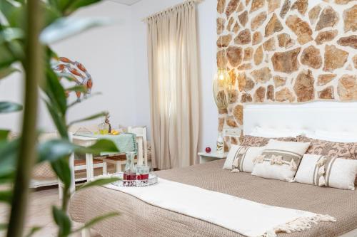 a bedroom with a bed and a stone wall at GOLDEN COAST NAXOS in Agios Prokopios