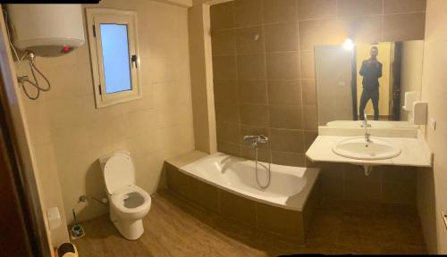 a bathroom with a toilet and a tub and a sink at Bahga Palace 2 Residential Apartments in Hurghada