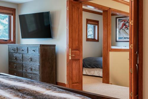 a living room with a television and a dresser at Creekside at Beaver Creek in Beaver Creek