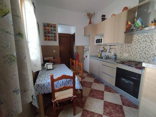 uma cozinha com uma mesa e uma cozinha com uma mesa e cadeiras em La casita de Poniente. Enjoy it! em Huelva