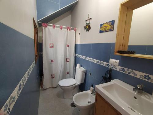 a blue and white bathroom with a toilet and a sink at La casita de Poniente. Enjoy it! in Huelva