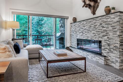 a living room with a fireplace and a couch at Creekside at Beaver Creek in Beaver Creek