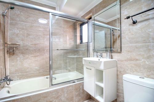 een badkamer met een douche, een wastafel en een toilet bij San Lameer Villa 2004 by Top Destinations Rentals in Southbroom