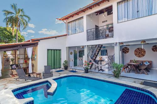 uma villa com piscina em frente a uma casa em SPA&Hospedagem Giovannini em Pirenópolis