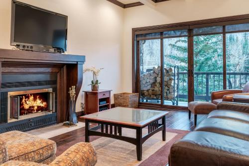 a living room with a fireplace and a tv at Creekside at Beaver Creek in Beaver Creek