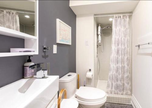多倫多的住宿－現代化設計公寓，浴室配有白色卫生间和盥洗盆。