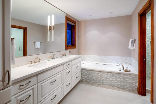 a bathroom with two sinks and a bath tub at Creekside at Beaver Creek in Beaver Creek