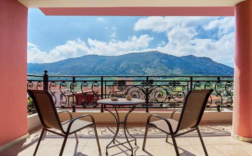 balkon ze stołem i krzesłami oraz widokiem na góry w obiekcie Arhontiko Arhanes Suites w mieście Archanes
