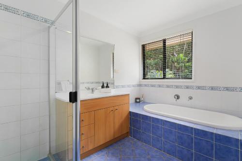 a bathroom with a tub and a sink at Heated Pool, Beach Side Entetainer, Sleeps 18 in Umina