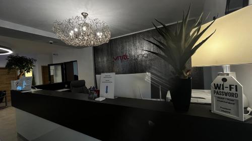 an office with a reception desk with a chandelier at VitaLounge Sports & Spa Hotel in Gelsenkirchen