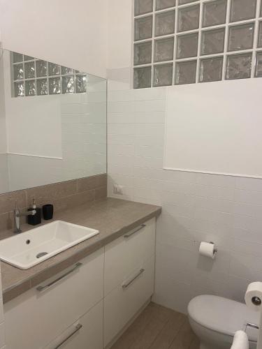 uma casa de banho branca com um lavatório e um WC em Alba - Le Grotte Rooms & Apartments em Camerano