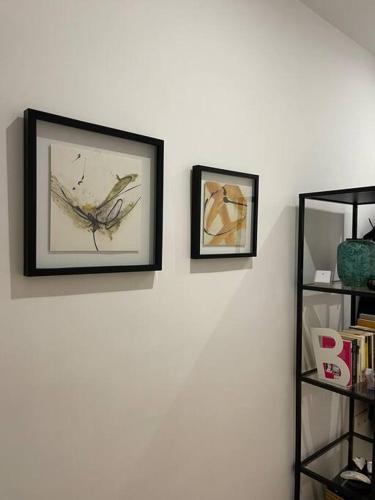 two framed pictures on a white wall with a shelf at HOME OF OLYMPOS in Litochoro