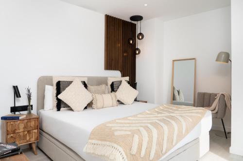 una camera da letto con un grande letto bianco con cuscini di TSA La Rambla a Barcellona