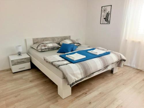 a bedroom with a bed with blue pillows on it at Apartment "None" Makarska in Makarska