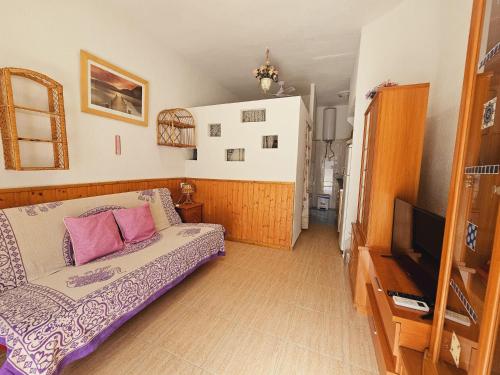 Sala de estar con cama y TV en Benidorm Bungalow la Siesta A26 en Benidorm