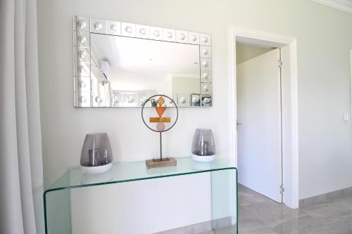 a room with a glass table and a mirror at Caribbean 1136 by Top Destinations Rentals in Port Edward