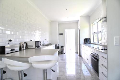 a white kitchen with white counters and white appliances at Caribbean 1136 by Top Destinations Rentals in Port Edward