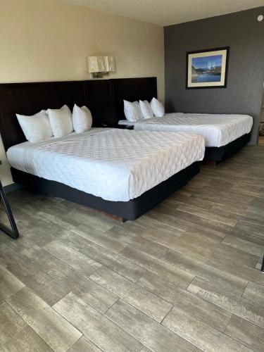 two beds sitting in a hotel room with at Ambassador Inn in Perryton