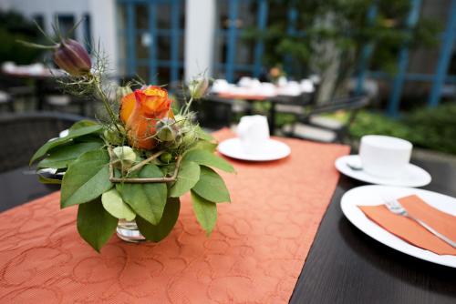 una mesa con un jarrón con una flor. en Hanns-Lilje-Haus, en Hannover