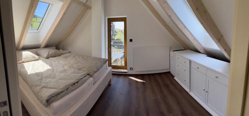 a small bedroom with a bed and a window at U Králíka, mezonetový apartmán H - 3 samostatné ložnice, vlastní parkování in Dolní Morava