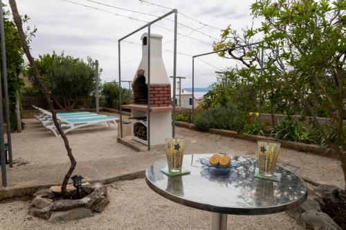 a table and a grill with two glasses on it at Apartment Pojatica Sumartin in Sumartin