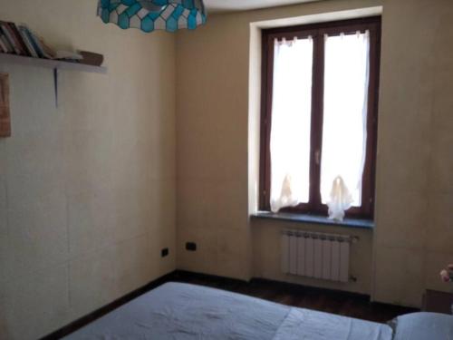- une chambre avec un grand lit et une fenêtre dans l'établissement Appartamento in cascina lombarda, à Caselle Lurani