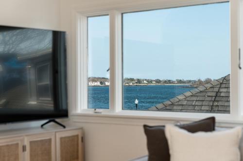 sala de estar con TV y vistas al agua en CbytheSea - Ocean View Penthouse, en Gloucester