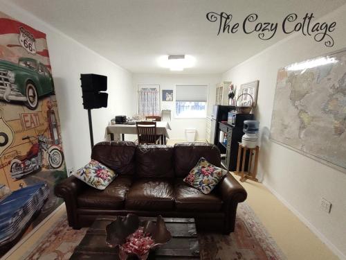 a living room with a brown leather couch at Cozy Cottage in Miramonte