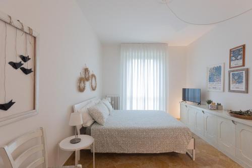 1 dormitorio blanco con 1 cama y TV en Marte 87 en Florencia