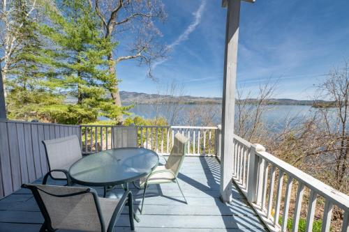 a porch with a table and chairs and a view of the water at Depe Dene Lakeside Resort in Lake George