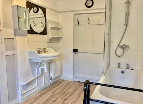 a bathroom with a sink and a tub and a shower at 24 Mill Green in Lyme Regis