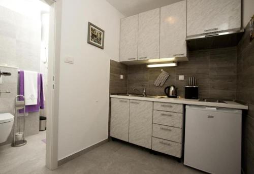 eine Küche mit weißen Schränken und einem Waschbecken in der Unterkunft Green Place in Split
