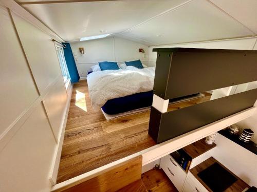 Habitación pequeña con cama y suelo de madera. en Tinyhouse „Kleines Ems-Idyll“ en Lathen