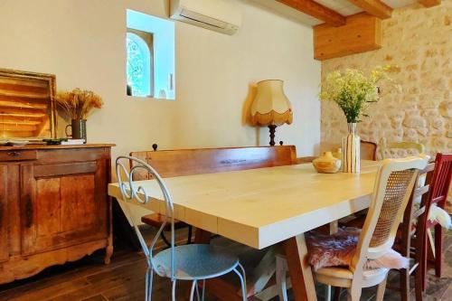 une salle à manger avec une table et des chaises en bois dans l'établissement Le Moulin Chardet, à Roullet-Saint-Estèphe