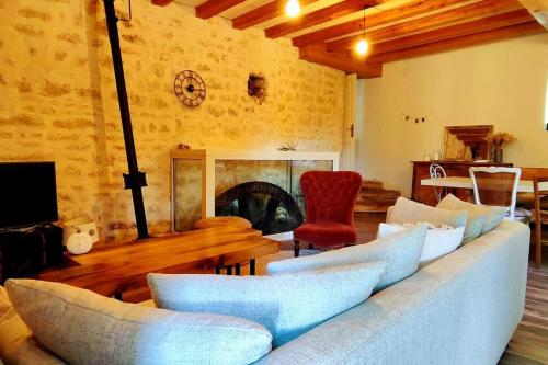 un salon avec un canapé et une cheminée dans l'établissement Le Moulin Chardet, à Roullet-Saint-Estèphe